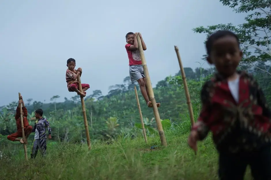 Anak-anak bermain di padang rumput hijau Ranca Upas, Ciwidey
